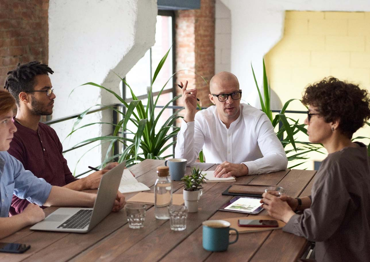 Team of professionals collaborating at a table, discussing agile software solutions.