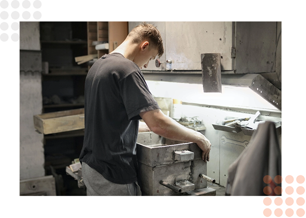 A worker operates machinery in a workshop focused on die cutting.