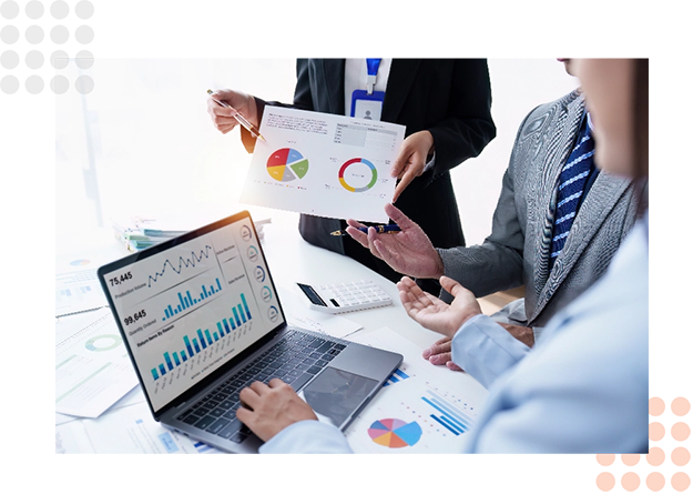 Professionals discuss charts and data while reviewing documents in a meeting.