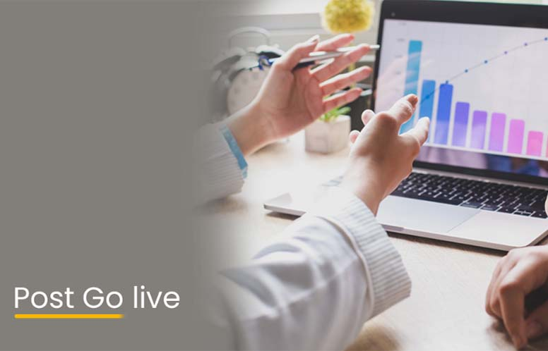 Hands gesturing towards a laptop displaying colorful charts and graphs in a meeting.