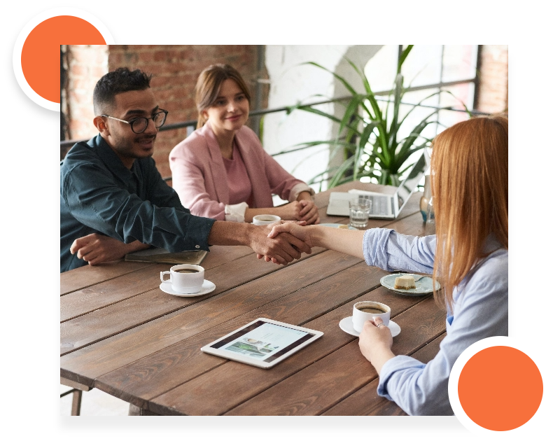 A group of professionals discussing documents and using a tablet during a meeting.
