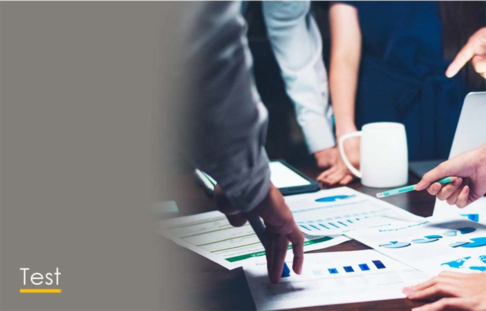 Hands pointing at charts and documents during a testing phase of a project.