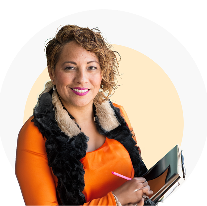 A smiling woman holding a notebook, looking confidently at the camera.