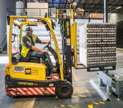 Worker operating a Hyster forklift in a warehouse, moving pallets efficiently, showcasing industrial operations related to financial and operations management in TechnicaX Dynamics 365.