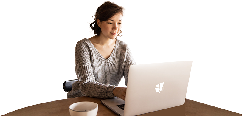 Woman using a laptop at a wooden table with a cup of coffee, representing analytics and business intelligence with Power BI by TechnicaX.