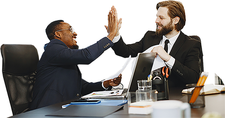 Two business professionals in formal attire high-fiving across a desk, representing successful collaboration and teamwork. Office setting with laptops and documents, aligning with TechnicaX's focus on SharePoint and collaborative business solutions.